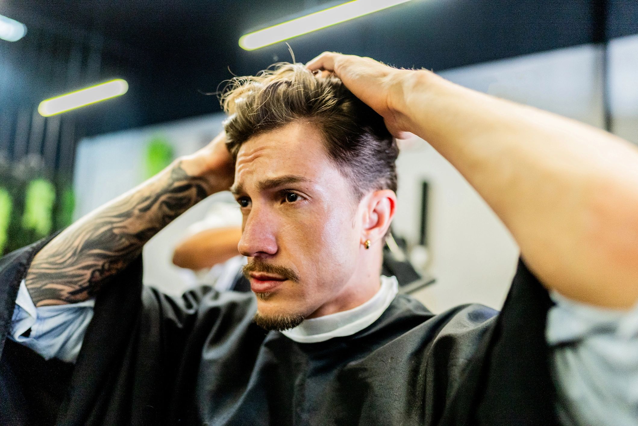 Client checking haircut result at a barber shop